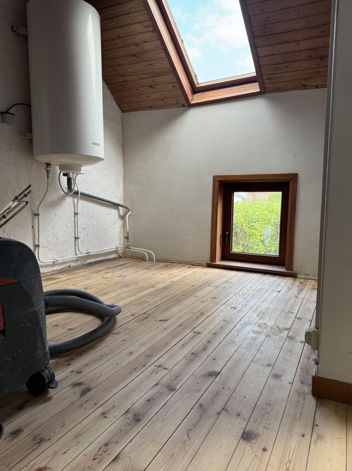 Aménagement de combles avec parquet et fenêtre de toit réalisé en Brabant wallon